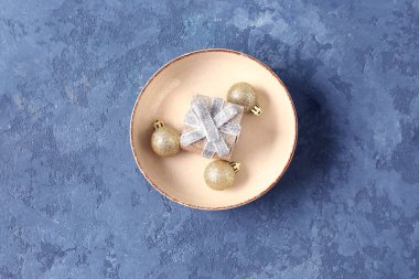 Noel topları ve mavi arka planda hediye kutusuyla güzel bir masa.