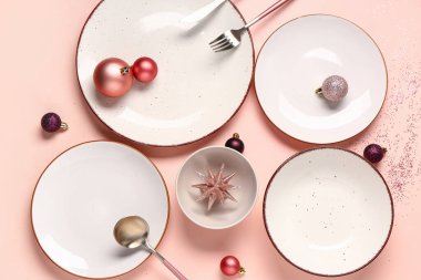 Pembe arka planda Noel topları olan güzel bir masa.