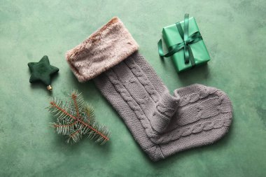 Güzel bir Noel çorabı hediye paketi ve yeşil arka planda süslemeler.