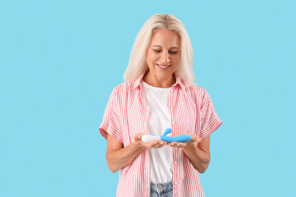 Mature woman with vibrator on blue background