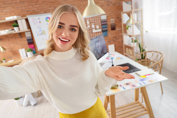 Female interior designer taking selfie in office