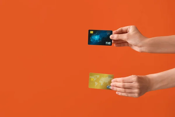 Woman with credit cards on orange background