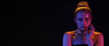 Koyu arkaplanda parıltılı makyajlı genç bir kadın ve metin için yeri var.