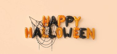 Bej arkaplanda balonlardan yapılmış Mutlu Cadılar Bayramı metni