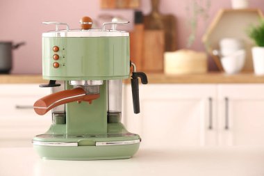 Mutfaktaki beyaz sehpada modern kahve makinesi.