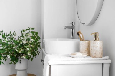 Lavabo kasesi ve banyo aksesuarları tuvalet masasının üzerinde.