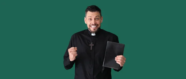 Glücklicher Priester Mit Bibel Auf Grünem Hintergrund — Stockfoto