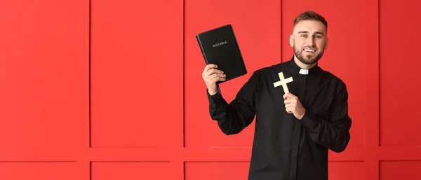 Jeune Prêtre Tenant Bible Croix Sur Fond Rouge Avec Espace — Photo