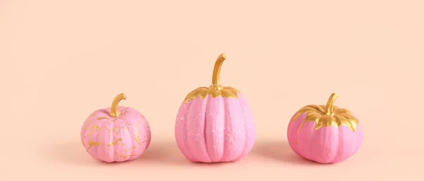 Beautifully painted pumpkins on light background
