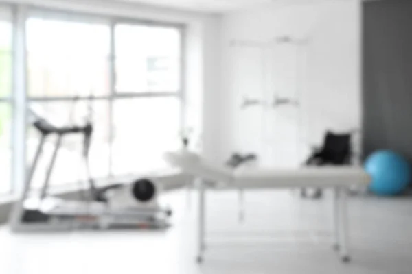 Blurred view of rehabilitation center with couch and equipment