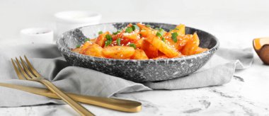 Arkaplanda bal biberli patates tabağı.