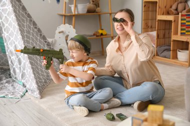 Dadı ve küçük çocuk evde oyuncaklarla oynuyor.