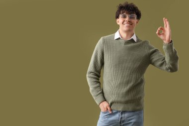 Gözlüklü yakışıklı adam yeşil arka planda iyi görünüyor.