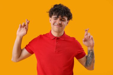 Genç adam sarı arka planda şans diliyor.