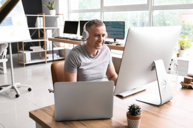 Açık ofiste çalışan olgun bir erkek programcı.