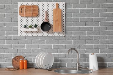 Modern mutfakta lavabo, tabak rafı ve mutfak aletleri beyaz tezgahlarda.