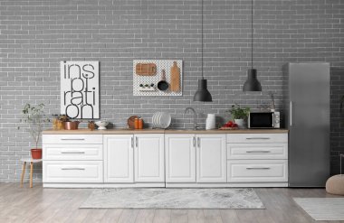 Modern mutfak, beyaz tezgahlar ve buzdolabı.