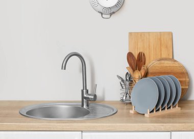 Kesme tahtaları, tabak rafları ve çatal bıçakları olan mutfak tezgahı.