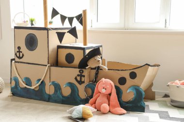 Çocuk odasında oyuncakları olan korsan karton gemi.
