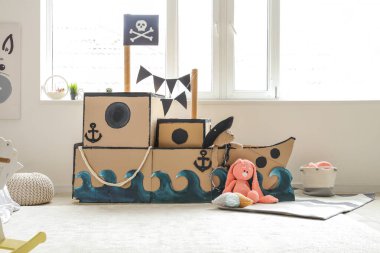 Çocuk odasında oyuncakları olan korsan karton gemi.