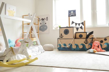 Çocuk odasında oyuncakları olan korsan karton gemi.