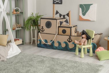 Çocuk odasının içinde korsan karton gemi.