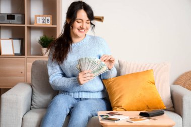 Evde para sayan genç bir kadın.