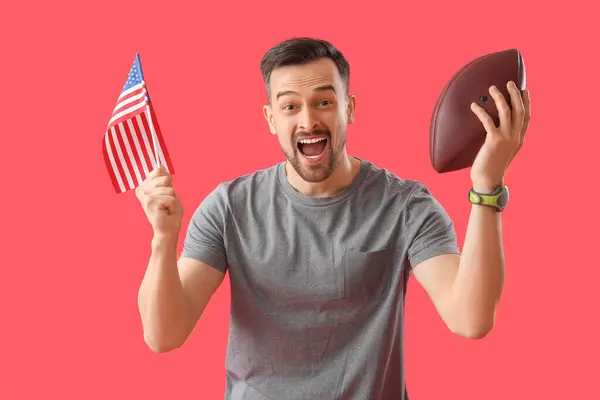 Happy young man with USA flag and rugby ball on red background