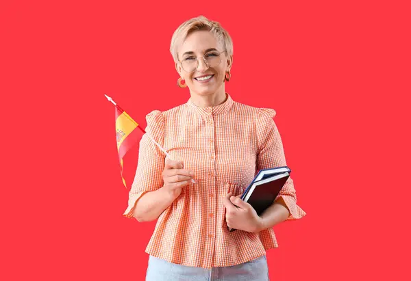Mature female teacher of Spanish on red background