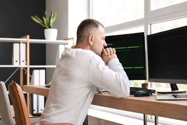 Mature male programmer working in light office