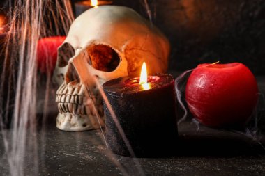 Siyah arka planda Cadılar Bayramı kutlamaları için farklı yanan mumlar, kafatası ve ağ kompozisyonu, yakın plan