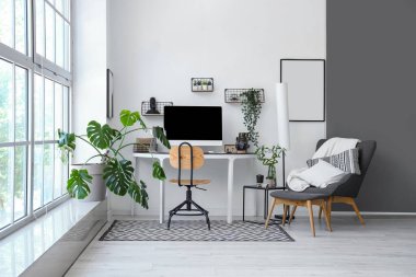 Modern işyeri ve ev bitkilerinin bulunduğu hafif bir ofis.