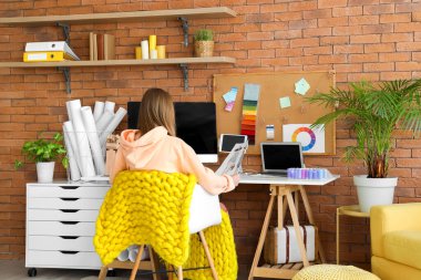 Ofisteki çizimlerle çalışan kadın moda tasarımcısı