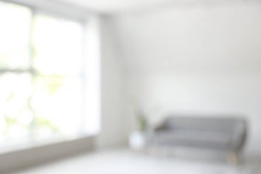 Oturma odasının içi bulanık, klimalı ve kanepeli.