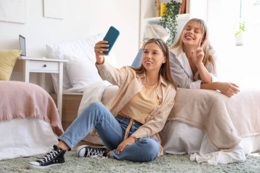 Yurt odasında selfie çeken kız öğrenciler.