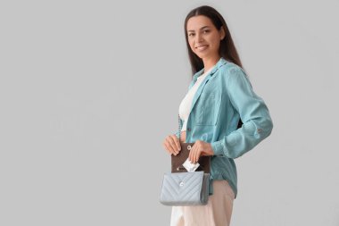 Prezervatifli, parlak arka planda genç bir kadın.