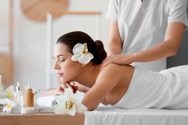 Kaplıca salonunda masaj yaptıran genç bir kadın, yakın plan.