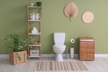 Tuvaletin içinde klozet, raf ünitesi ve sepet var.