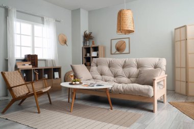 Koltuğu, koltuğu ve masası olan bir oturma odası.