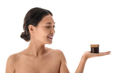 Beyaz arka planda krema kavanozu olan güzel Asyalı kadın, yakın plan.