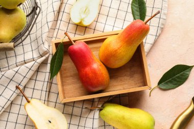 Bej arka planda olgun armutlarla ahşap kutu.