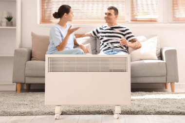 Genç bir çiftin oturma odasında modern radyatör.