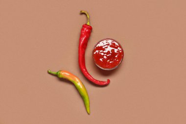 Lezzetli salsa soslu kase ve kahverengi arka planda kırmızı biber.