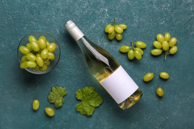 Arka planda üzümlü bir şişe beyaz şarap.