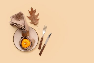 Bej arka planda balkabağı ve sonbahar yaprağı ile güzel masa ayarları