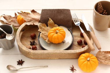 Beyaz ahşap zemin üzerinde balkabakları, kestaneler ve kuru yapraklar ile sonbahar masa ayarı