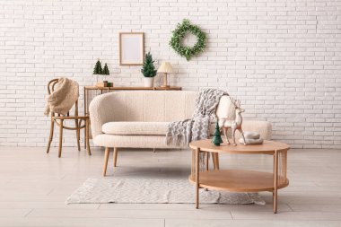 Beyaz kanepesi, kahve masası ve Noel süslemeleri olan festival salonu.