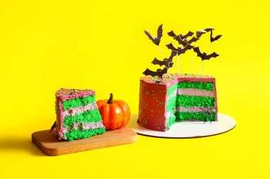 Sarı arka planda yarasalar ve balkabağı olan lezzetli Cadılar Bayramı pastası