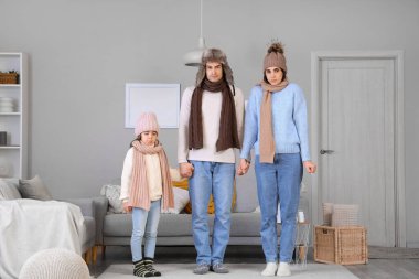 Kalorifersiz, kalın elbiseli, donmuş bir aile.