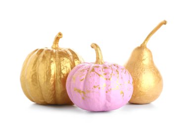 Beyaz arka planda farklı boyalı balkabakları ve altın armut